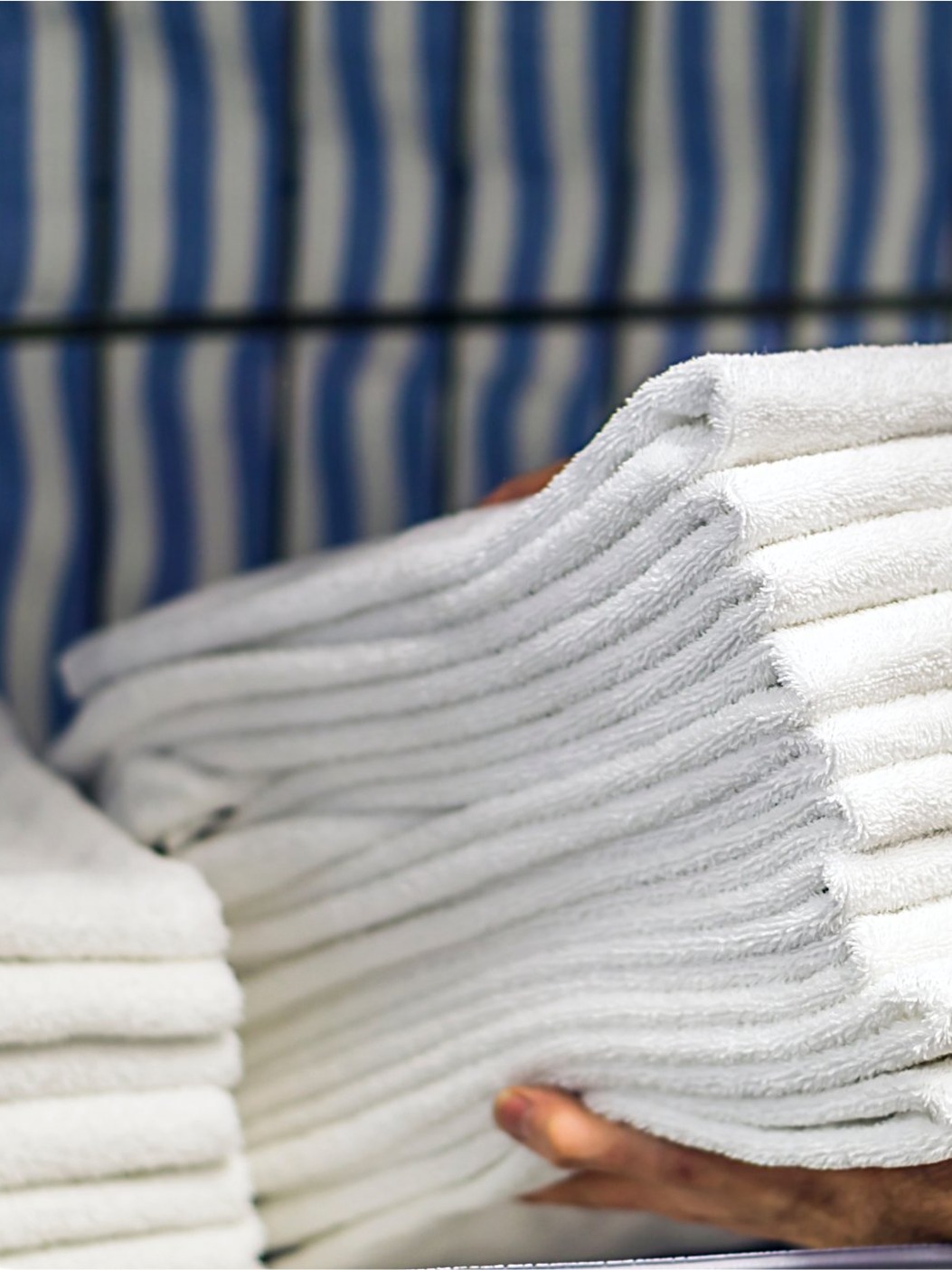 Freshly folded commercial towels stacked and handed off, ready for delivery