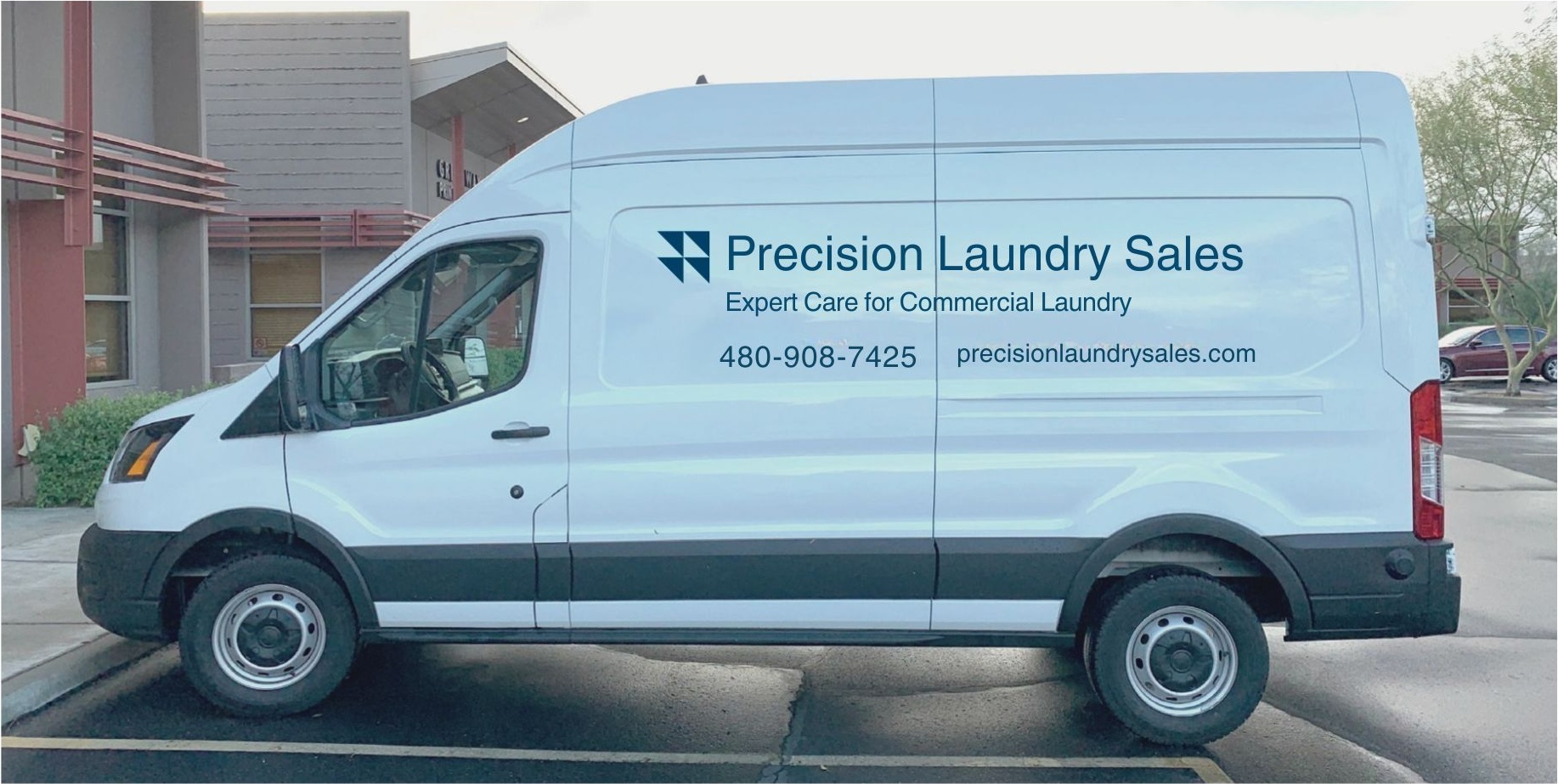 Precision Laundry Sales branded commercial cargo van parked outside a Phoenix-area business