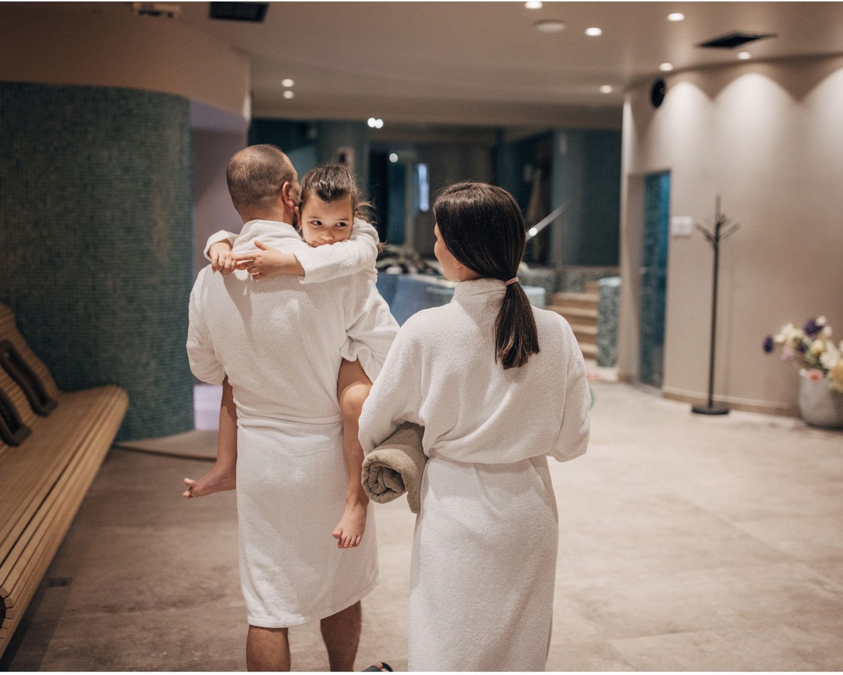 Family in fresh white spa robes and towels at a wellness facility